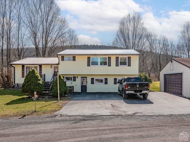 tri-level home with an outdoor structure, metal roof, and a front lawn