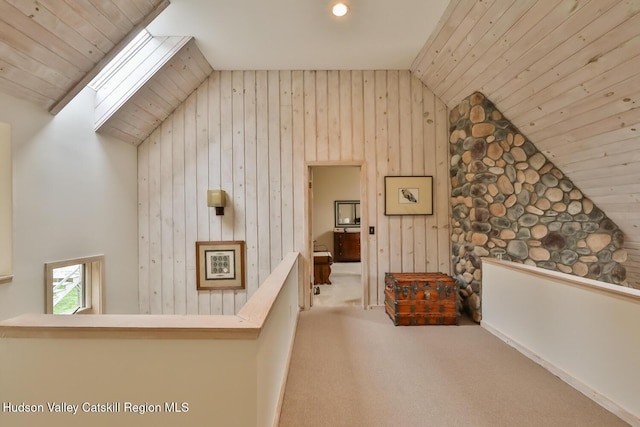 122 Brainard Ridge Rd Unit 14F, Windham, NY 12496 - corridor featuring lofted ceiling, an upstairs landing, wooden walls, a skylight, and carpet floors