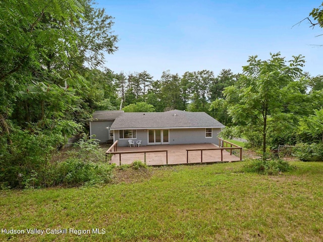 back of house featuring a lawn and a wooden deck