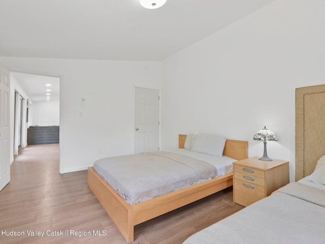 bedroom with hardwood / wood-style floors and vaulted ceiling