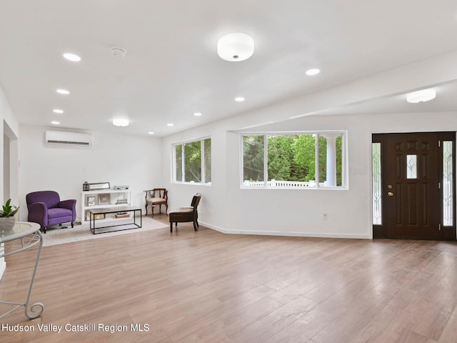 entryway with light wood-type flooring and an AC wall unit