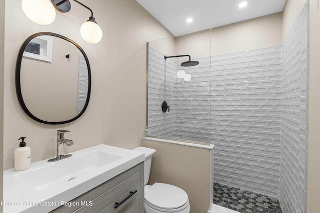 bathroom with toilet, vanity, and a walk in shower