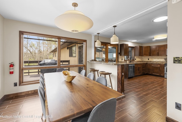 dining room featuring wood tiled floor and baseboards