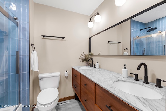 full bathroom with visible vents, toilet, tiled shower, and a sink