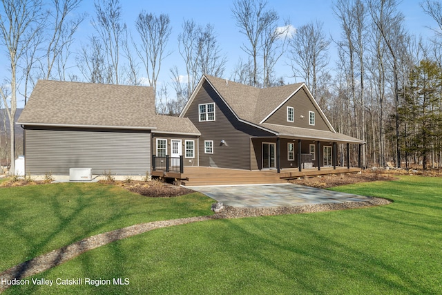 back of property with a lawn and a shingled roof