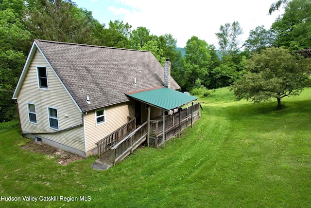 515 Delaware Ave, Andes, NY 13731 - back of house featuring a chimney, a lawn, roof with shingles, and view of wooded area