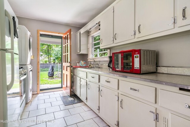 3271 Rte 212, Bearsville, NY 12409 - kitchen with light tile patterned floors, freestanding refrigerator, a sink, and white cabinetry