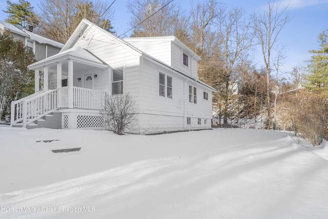 snow covered property with a porch