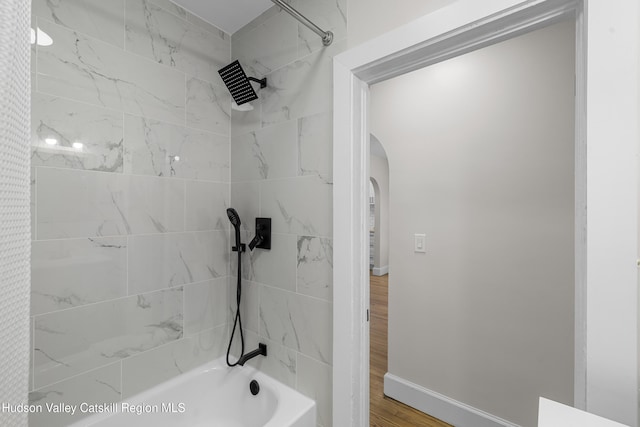 bathroom featuring wood-type flooring and shower / tub combo