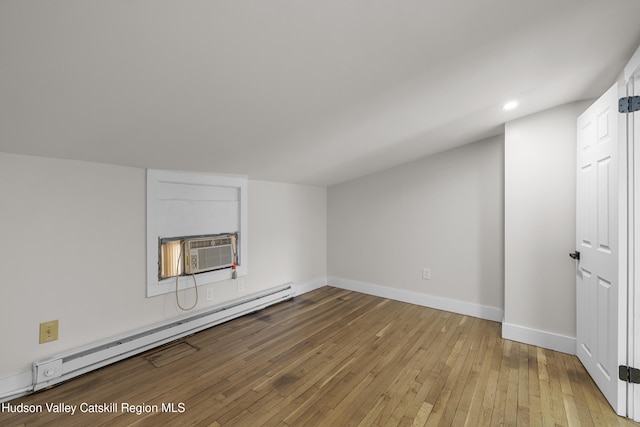 additional living space featuring light hardwood / wood-style floors and a baseboard heating unit