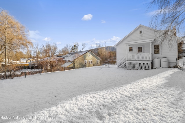 view of snow covered back of property