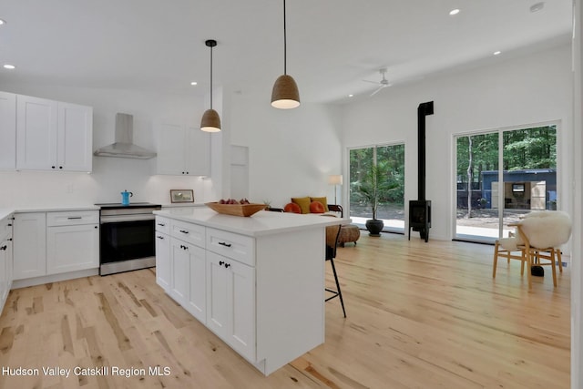 377 Pennsylvania Ave, Palenville, NY 12463 - kitchen with electric stove, wall chimney exhaust hood, recessed lighting, light wood finished floors, and ceiling fan