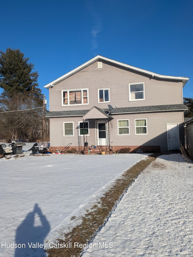 view of snow covered rear of property