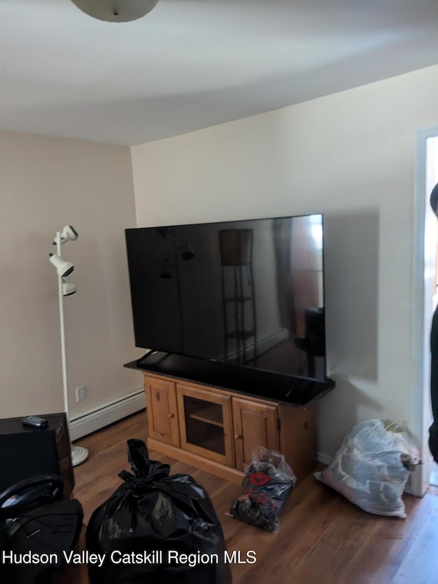 living room with dark hardwood / wood-style floors and a baseboard heating unit