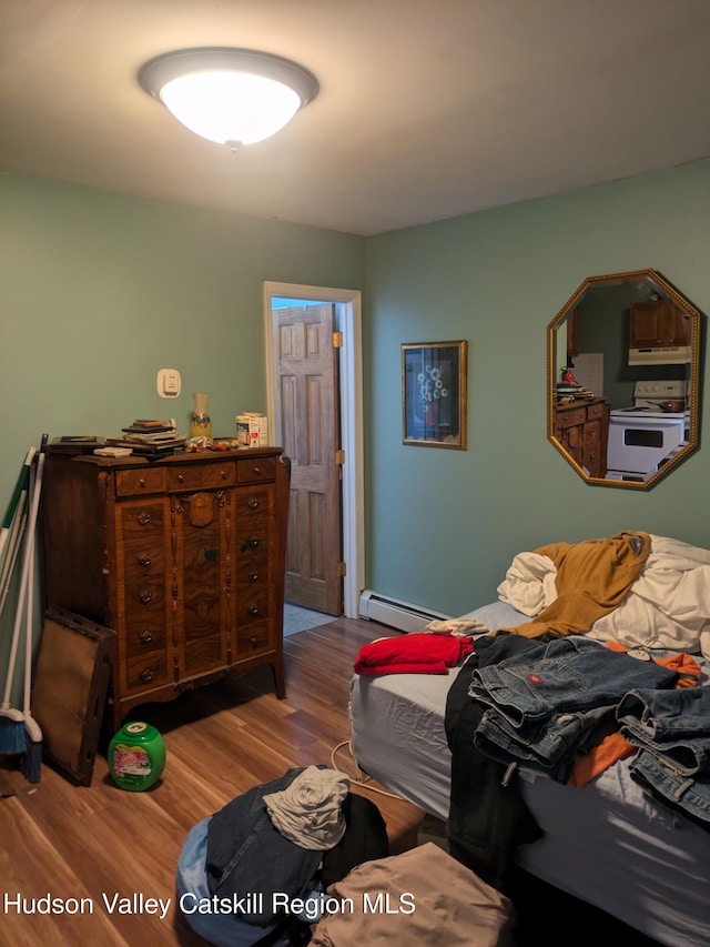 bedroom featuring light hardwood / wood-style floors and a baseboard heating unit