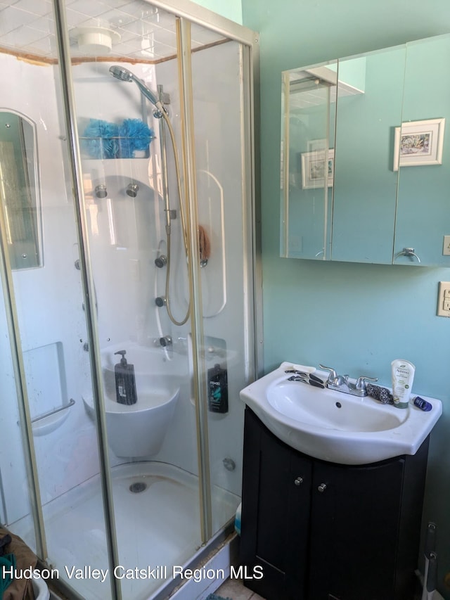 bathroom featuring vanity and a shower with door