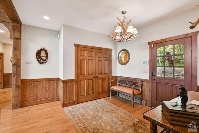 19 Twin Maples Ln, Windham, NY 12496 - foyer entrance with wainscoting, light wood-style flooring, a chandelier, and wood walls