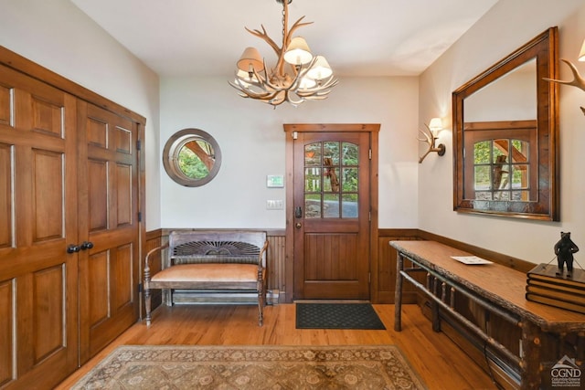 19 Twin Maples Ln, Windham, NY 12496 - foyer with light wood finished floors, wainscoting, a chandelier, and wooden walls