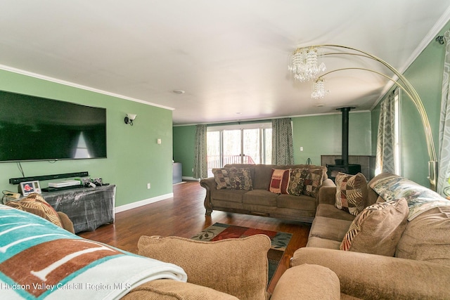 living room with dark hardwood / wood-style floors, a wood stove, ornamental molding, and a chandelier