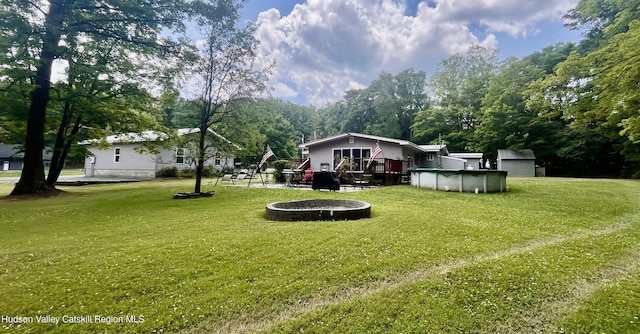 view of yard featuring a swimming pool side deck and a trampoline