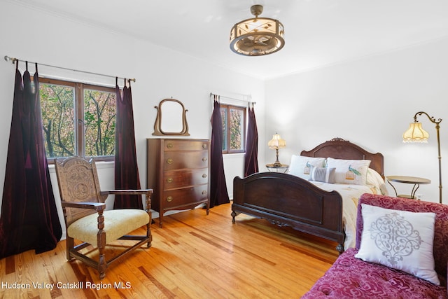 bedroom with wood-type flooring and ornamental molding