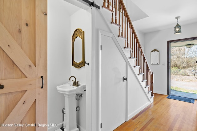 interior space with a barn door, hardwood / wood-style floors, and sink