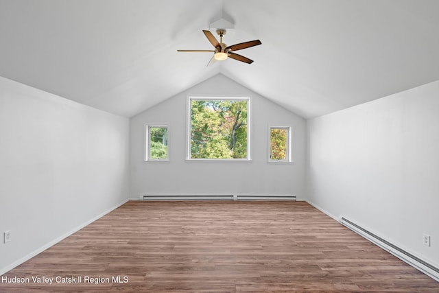 additional living space featuring plenty of natural light, light hardwood / wood-style floors, and a baseboard radiator