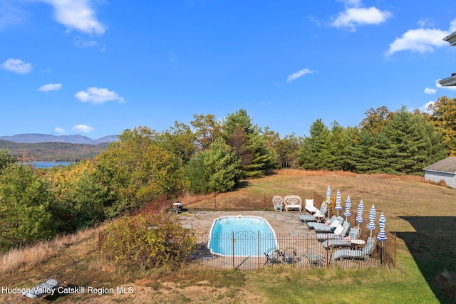 view of swimming pool with a mountain view and a patio