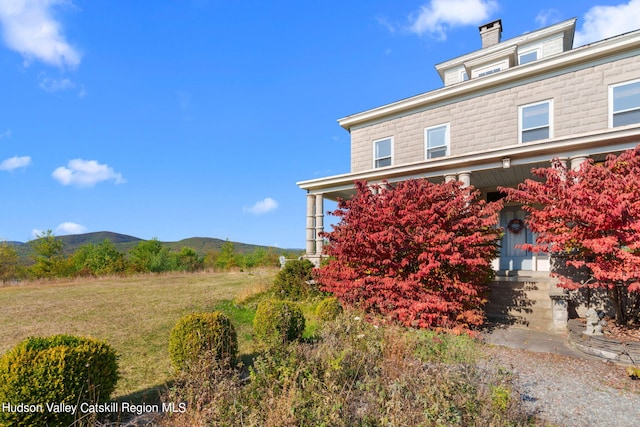 view of side of property featuring a mountain view and a yard