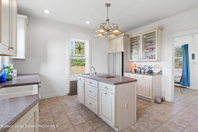 kitchen with sink, a center island, decorative light fixtures, cream cabinetry, and high quality fridge