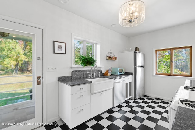 kitchen featuring sink, white cabinets, a healthy amount of sunlight, and white appliances