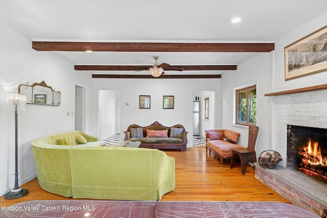 living room with a fireplace, hardwood / wood-style floors, and beamed ceiling