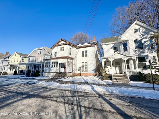 view of front of property with covered porch and a chimney