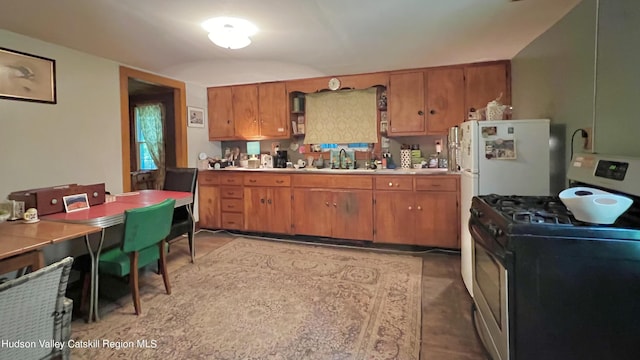 kitchen featuring white range with gas stovetop and sink