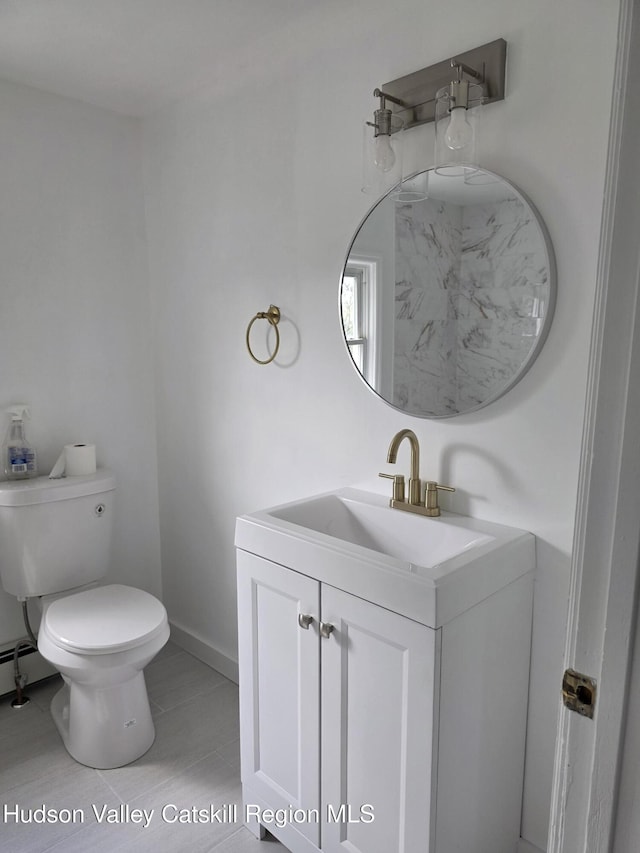 half bathroom featuring toilet, vanity, and baseboards