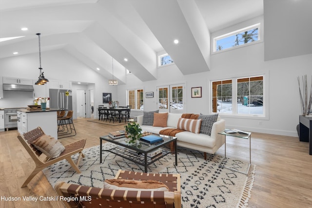 living room with high vaulted ceiling, light wood-style flooring, baseboards, and recessed lighting