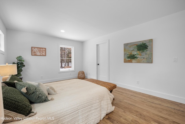 bedroom with recessed lighting, wood finished floors, and baseboards