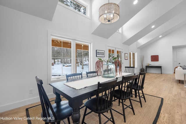 dining room featuring a chandelier, light wood-type flooring, french doors, and baseboards