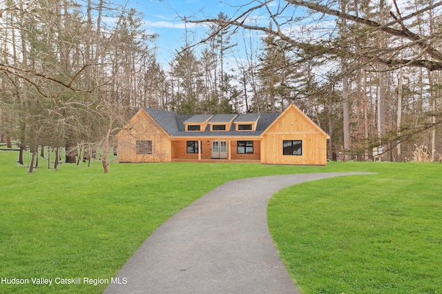 view of front of home featuring a front lawn and roof with shingles