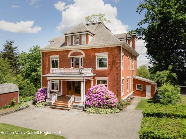 12 W Chestnut St, Kingston, NY 12401 - colonial-style house with covered porch, a balcony, brick siding, and roof with shingles