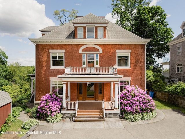 12 W Chestnut St, Kingston, NY 12401 - traditional style home featuring covered porch, a balcony, brick siding, and a shingled roof