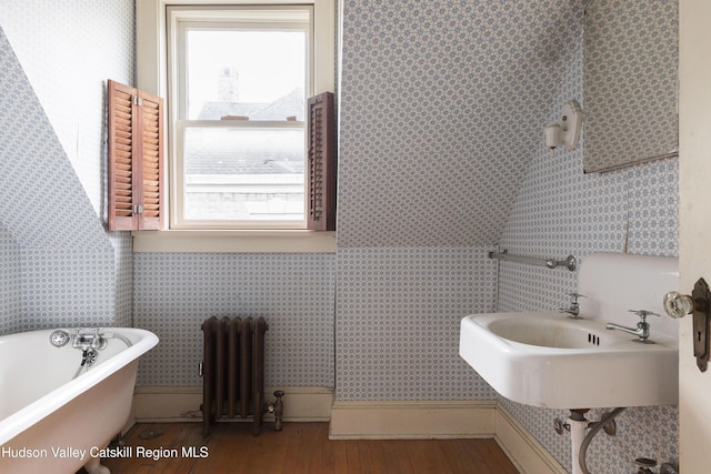 12 W Chestnut St, Kingston, NY 12401 - bathroom with radiator, a freestanding bath, hardwood / wood-style floors, and wallpapered walls