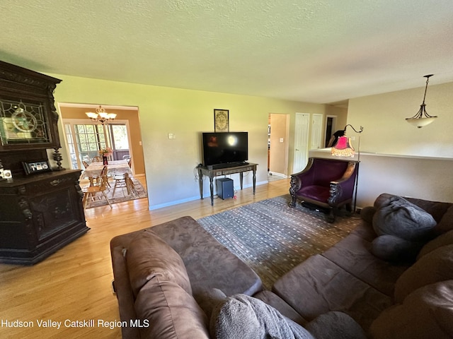 36 Susi Oval, Modena, NY 12548 - living area with a chandelier, light wood-type flooring, baseboards, and a textured ceiling