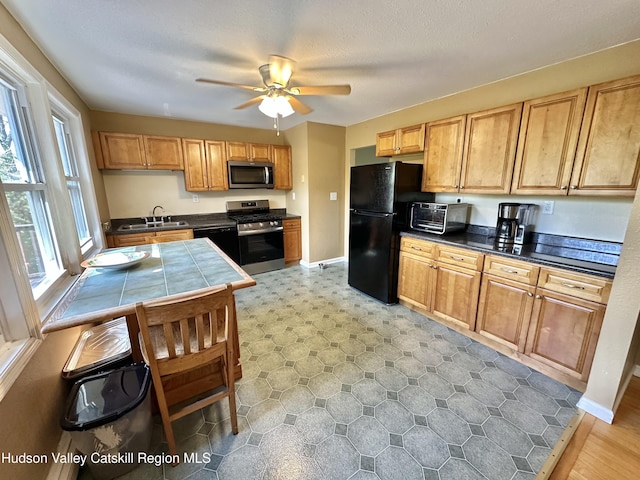 36 Susi Oval, Modena, NY 12548 - kitchen with black appliances, a sink, a ceiling fan, tile counters, and baseboards
