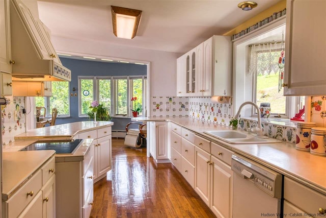 kitchen featuring dishwasher, a baseboard heating unit, sink, backsplash, and black electric cooktop