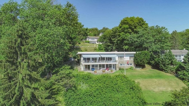 rear view of property featuring a lawn