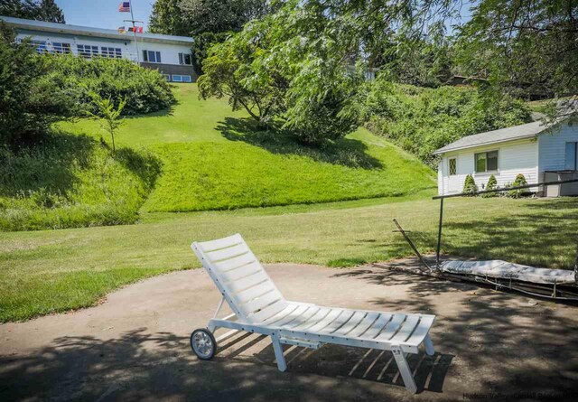 view of community featuring a lawn and a patio