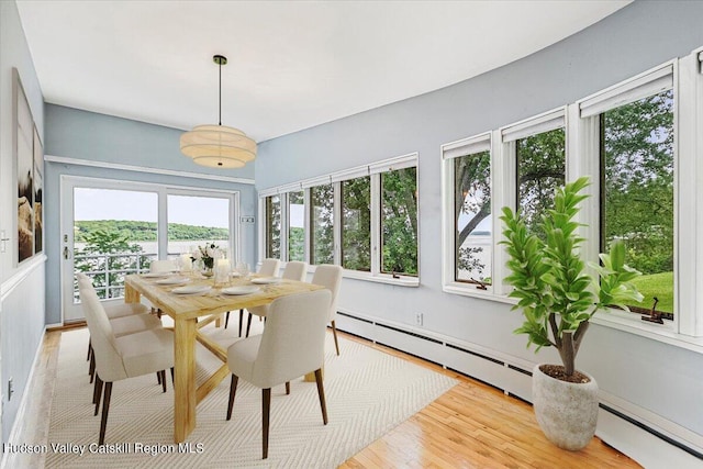 dining space with baseboard heating and light hardwood / wood-style flooring