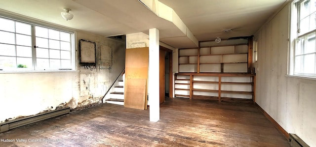 basement featuring baseboard heating and dark wood-type flooring