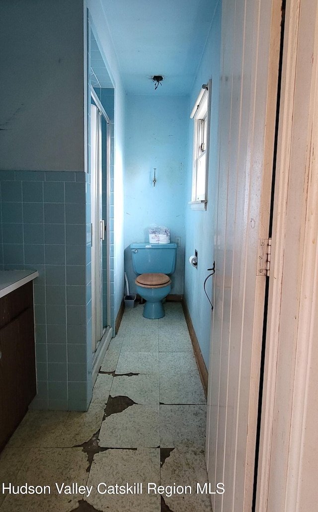 bathroom with walk in shower, vanity, and toilet